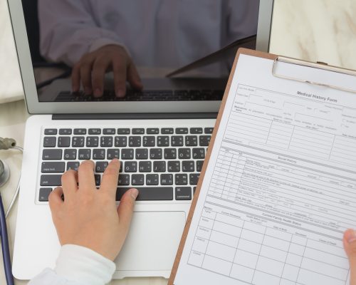 Doctor hands typing on laptop keyboard